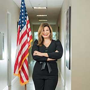photo of attorney Sandra Echevarria standing next to the U.S. flag