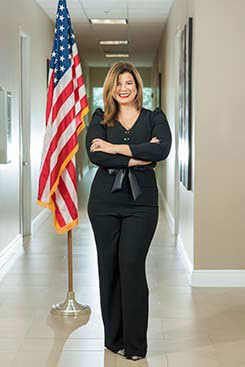 photo of attorney Sandra Echevarria standing next to the U.S. flag